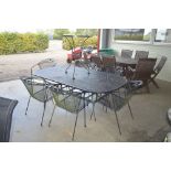 A large metal garden table; with a set of matching