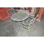 A cast metal garden table; with a pair of chairs