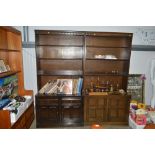 Two dark Ercol dressers each raised on cupboard ba