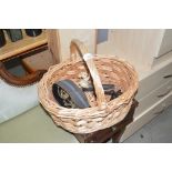 A wicker basket containing a horse brass, door han