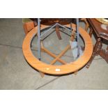 A teak and glass top circular coffee table