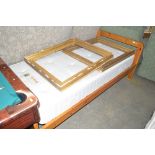 A pine single bed frame with mattress