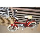 A child's red bicycle; and a pair of stabilisers