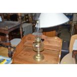 A brass and glass oil lamp with clear glass reserv