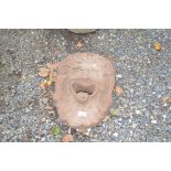 A terracotta wall mounted face mask