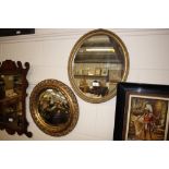 A gilt framed oval wall mirror