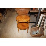 A reproduction yew wood two tier table raised on c