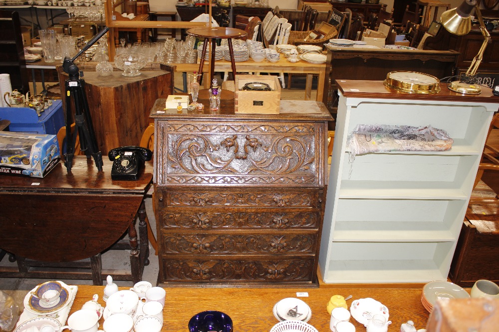 A late Victorian carved oak bureau fitted four lon