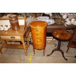 A circular wooden chest fitted six drawers