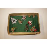 A tray of Christmas related brooches