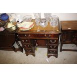 A reproduction mahogany kneehole writing desk with