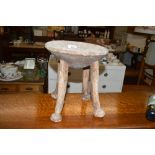 An ethnic carved wooden four legged stool