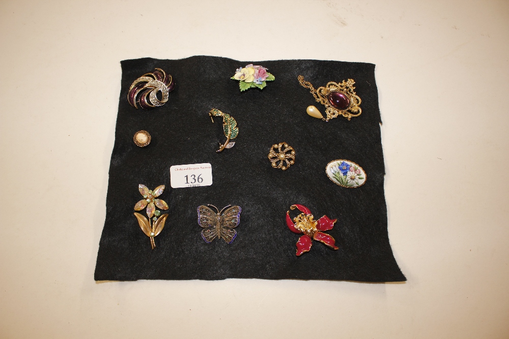 Ten various costume brooches on cloth