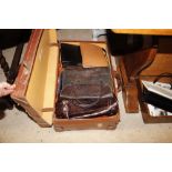 An old brown leather suitcase containing lady's ba