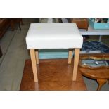 A leatherette upholstered stool