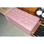 A pink upholstered ottoman