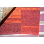 An approx 5'7" x 4' modern red wool rug