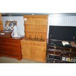 A light oak dresser raised on cupboard base fitted