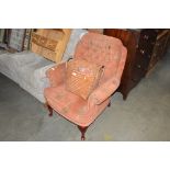 A buttoned down upholstered armchair raised on squ