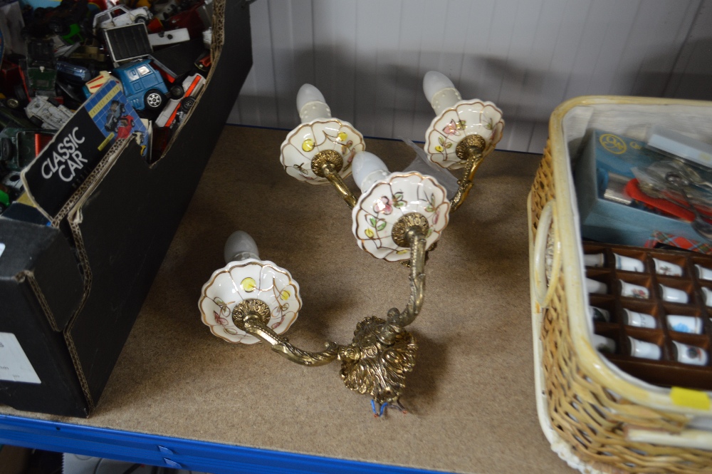 A pair of china and brass wall lights