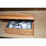 A carved wooden sewing box and contents