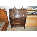 An oak bureau fitted three long drawers