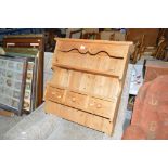 A hanging pine shelf fitted three drawers