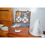 A wicker picnic hamper and contents