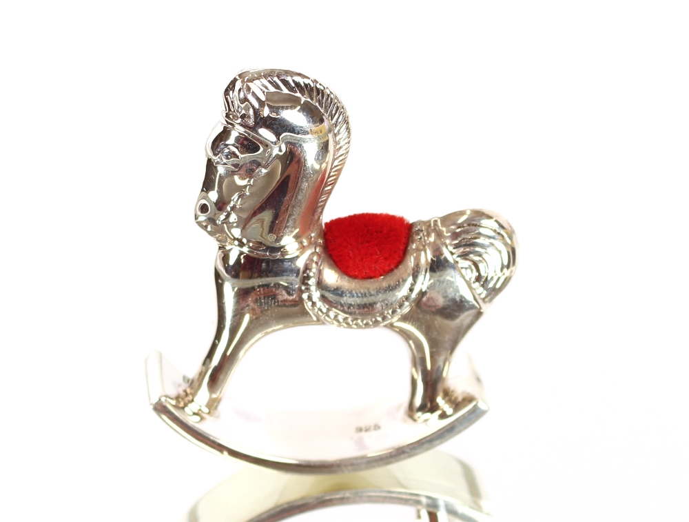 A silver rocking horse pin cushion