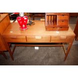 A teak hall table fitted three drawers, raised on