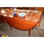 A fruit wood drop leaf dining table raised on squa