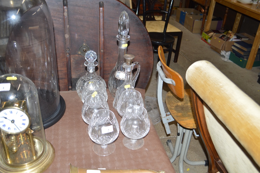 Five glass brandy balloons, two decanters each wit