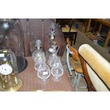 Five glass brandy balloons, two decanters each wit