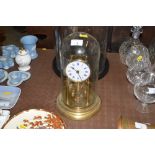 A brass anniversary clock under glass dome