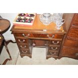 A reproduction mahogany kneehole writing desk wi