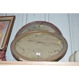 A gilt framed oval wall mirror; and a mahogany fra