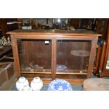 An oak and glazed wall cabinet