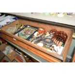 A wooden tray containing lady's evening purses, co