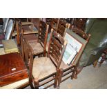 A set of four oak and ladder back rush seated chai