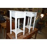A pair of white painted bedside tables