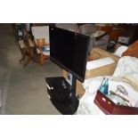 A Sony flat screen television on stand with remote