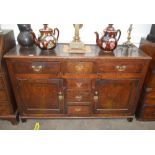 A 18th Century oak dresser base, fitted four central drawers flanked by larger drawers and