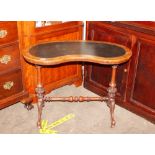 A Victorian walnut kidney shaped writing table, having leather inset top raised on shaped baluster