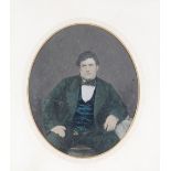 A late 19th / early 20th Century oval photographic print, of a seated gentleman contained in gilt