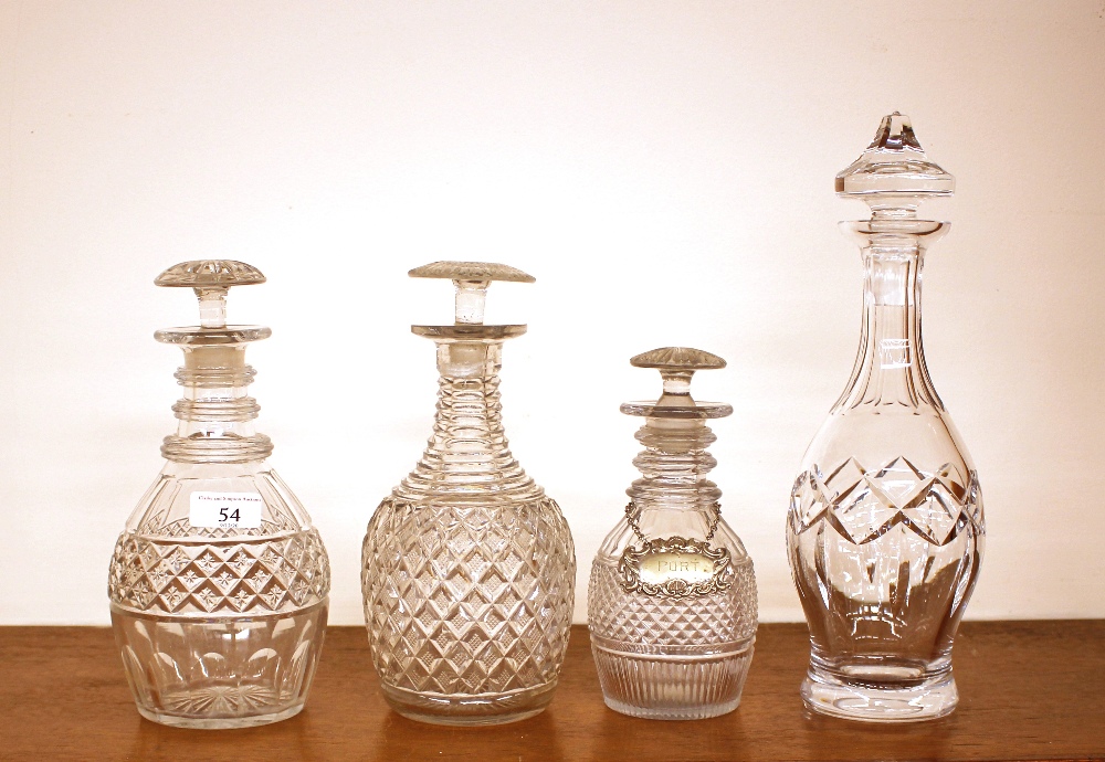 Three hobnail cut ring neck decanters, having mushroom stoppers; and a baluster shaped cut glass