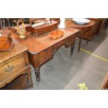 A Victorian mahogany side table, fitted five drawers around a carved central frieze, raised on