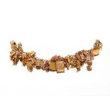 A 9ct gold charm bracelet, hung with various 9ct gold and yellow metal charms to include a 1913 half