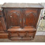 An 18th Century oak press cupboard, the upper hanging section enclosed by a pair of fielded panel