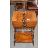 A Victorian walnut sewing table, the folding top revealing a silk lined interior beneath a turned