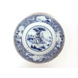 A Delft blue and white charger, decorated with a central scenic panel of a boy and shepherdess,